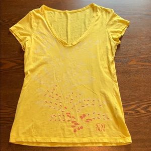 Yellow t-shirt with some floral designs.